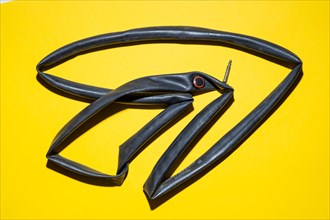 Top view of a flat bicycle tube against a yellow background