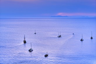 Aerial view of numerous sailboat and yachts go to sea for sunset or sunrise. Calm sea waters