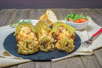 Green peppers stuffed with meat and rice in a salty tomato and lamb's lettuce sauce
