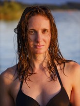 Young woman with wet long hair in bikini