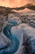 Meltwater stream on the glacier at sunset