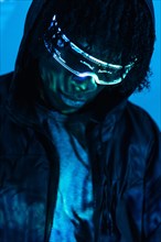 Close-up studio photo with blue neon light of a futuristic man with artificial intelligence headset