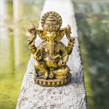Gold Ganesha statue on a trunk over the water