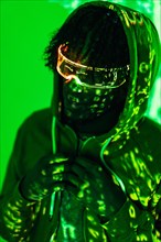 Vertical photo with green neon lights of the projection on a man wearing futuristic glasses