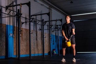 Dark and artistic portrait with artificial lights of a sportive disabled man training with a kettlebell