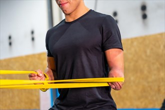Close-up of a handicapped man using an elastic band to work out in a cross training gym