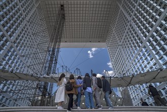 Tourists take a souvenir photo in the Grand Arche