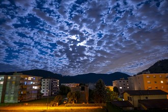 City with Moon and Sky With Cloudscape at Night in Caslano