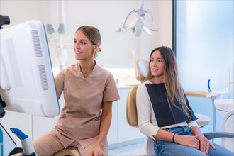 Customer and dentist looking at the results in a screen in a modern dental clinic