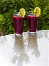 Freshly squeezed juice of beetroot with apple and lemon in a juice glass