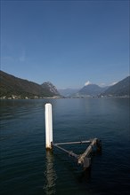 Pier in Brusino Arsizio on the Waterfront in a Sunny Summer Day on Lake Lugano and Mountain in Brusino Arsizio
