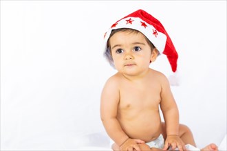 A baby boy with a red Christmas hat on a white background
