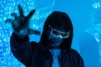 Studio photo with blue neon light of a man grabbing the future wearing augmented reality goggles