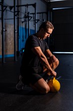 Dark and artistic portrait of a strong man with an arm amputated training in a gym