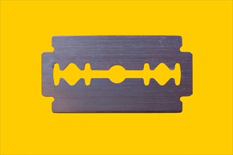 Razor blade against yellow background