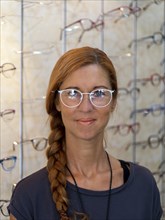 Woman at optician tries on new glasses
