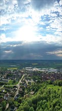 Aerial view of Koenigsberg in Bavaria. The city is surrounded by hills and forests. The sky is cloudy and dark