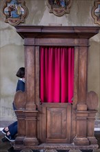 Woman Confesses Inside a Beautiful Church of San Carpoforo with Sunlight in Bissone