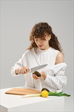 Nutritionist woman cutting fresh avocado into halves. Concept of balanced eating