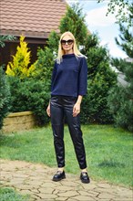 Full length portrait of blonde woman in trendy outfit outdoors