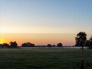 Sunrise and dawn behind the meadows and pastures