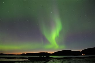 Intense aurora borealis over a fjord