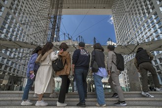 Tourists take a souvenir photo in the Grand Arche