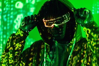 Portrait with green neon light of a man in a hoodie in virtual metaverse world