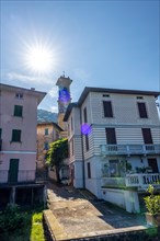 City of Porto Ceresio and Church Tower in a Sunny Summer Day with Sunbeam in Porto Ceresio