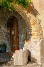 Beautiful Old Corner Below an Arch on a Narrow Street with a Armchair and Entrance Door with Sunlight in Bissone