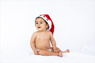 A baby boy with a red christmas hat on a white background