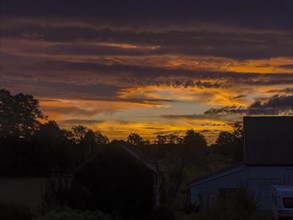 Colourful sunrise with cloud colouring and old farmhouse