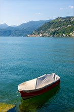 One Boat on the Waterfront in a Sunny Summer Day and on Lake Lugano and Mountain View over Morcote