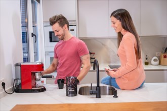 Man preparing coffee for his partner in the kitchen in the morning