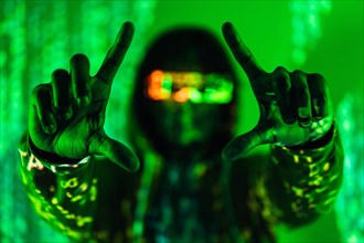 Photo with green neon lights of the projection on a man wearing futuristic glasses gesturing a frame