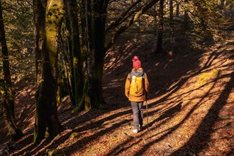 A young hiker on a trail in the Artikutza natural park on an autumn afternoon