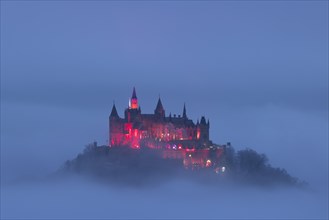 Hohenzollern Castle with Christmas lights in the fog from the Zeller Horn
