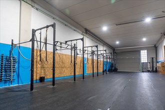 Empty space of a cross training room with bars and Olympic rings