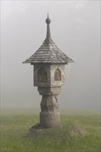 Wayside shrine in the autumnal fog