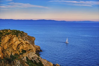 Lonely sailboat or small yacht navigating in harbour of Aegean sea near cape Sounion
