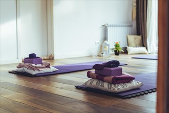 Empty yoga studio interior with mats and accessories. Copy space