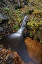 Mountain stream and waterfall in autumn forest