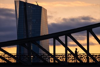 The sun rises behind the European Central Bank