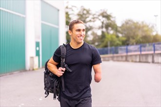 Happy and young athlete with one arm amputated arriving at the gym