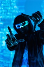 Vertical photo with blue neon light of a futuristic man gesturing while wearing VR goggles