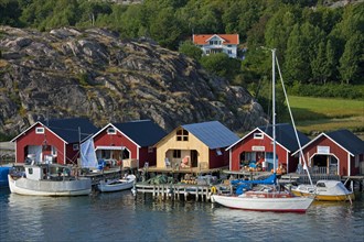 Red wooden boat huts in the harbour at Hamburgsund