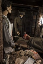 Diorama of British almoner and doctor treating wounded soldier in dugout of First World War One trench in the Memorial Museum Passchendaele 1917 at Zonnebeke