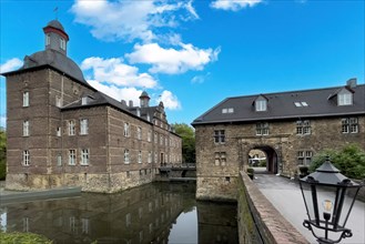 View of the main house of the moated castle Schloss Hugenpoet on the left