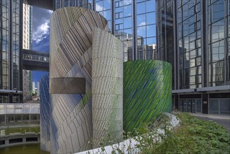 Art object the mosaic by artist Michel Deverne in front of office skyscrapers