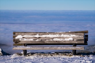 A frozen lookout bench with a view of the sea of fog at Brauneck in Lenggries